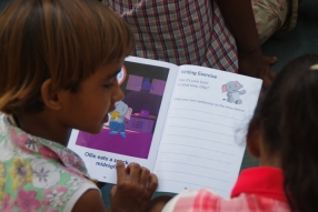 Children study English using the <i>Ollie the Elephant</i> books, at one of the slums in India where Charity United's educational programs are in operation.