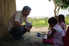 Children study English using the <i>Ollie the Elephant</i> books, at one of the slums in India where Charity United's educational programs are in operation.