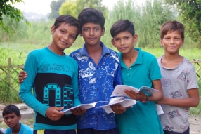 Children study English using the <i>Ollie the Elephant</i> books, at one of the slums in India where Charity United's educational programs are in operation.