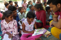 Children study English using the <i>Ollie the Elephant</i> books, at one of the slums in India where Charity United's educational programs are in operation.