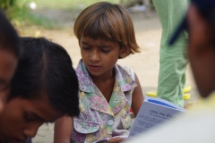 Children study English using the <i>Ollie the Elephant</i> books, at one of the slums in India where Charity United's educational programs are in operation.