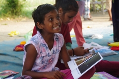 Children study English using the <i>Ollie the Elephant</i> books, at one of the slums in India where Charity United's educational programs are in operation.