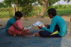 Children study English using the <i>Ollie the Elephant</i> books, at one of the slums in India where Charity United's educational programs are in operation.