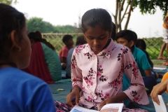 Children study English using the <i>Ollie the Elephant</i> books, at one of the slums in India where Charity United's educational programs are in operation.