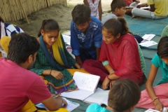 Children study English using the <i>Ollie the Elephant</i> books, at one of the slums in India where Charity United's educational programs are in operation.