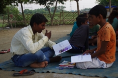 Children study English using the <i>Ollie the Elephant</i> books, at one of the slums in India where Charity United's educational programs are in operation.