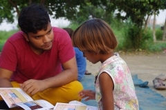 Children study English using the <i>Ollie the Elephant</i> books, at one of the slums in India where Charity United's educational programs are in operation.