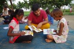 Children study English using the <i>Ollie the Elephant</i> books, at one of the slums in India where Charity United's educational programs are in operation.