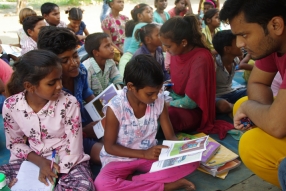 Children study English using the <i>Ollie the Elephant</i> books, at one of the slums in India where Charity United's educational programs are in operation.