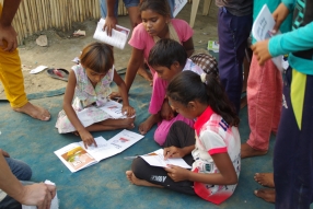 Children study English using the <i>Ollie the Elephant</i> books, at one of the slums in India where Charity United's educational programs are in operation.