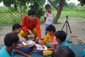Children study English using the <i>Ollie the Elephant</i> books, at one of the slums in India where Charity United's educational programs are in operation.