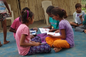 Children study English using the <i>Ollie the Elephant</i> books, at one of the slums in India where Charity United's educational programs are in operation.